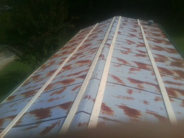 Rusted metal roof panels with new wood purlins before replacement — Storm Damage Roof Repair in Merced by Roofing Brothers