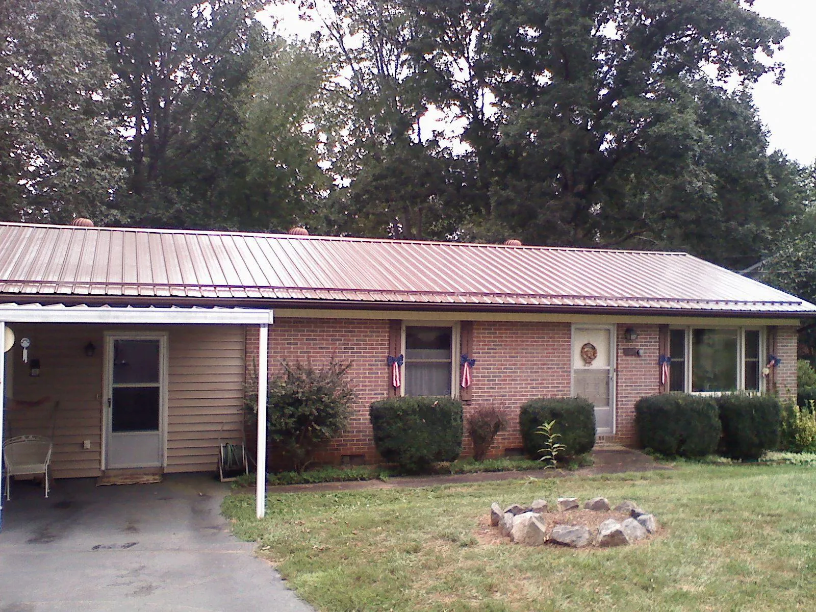 Bronze metal roof and carport on a brick ranch home — Roof Repair work by our crew in Merced