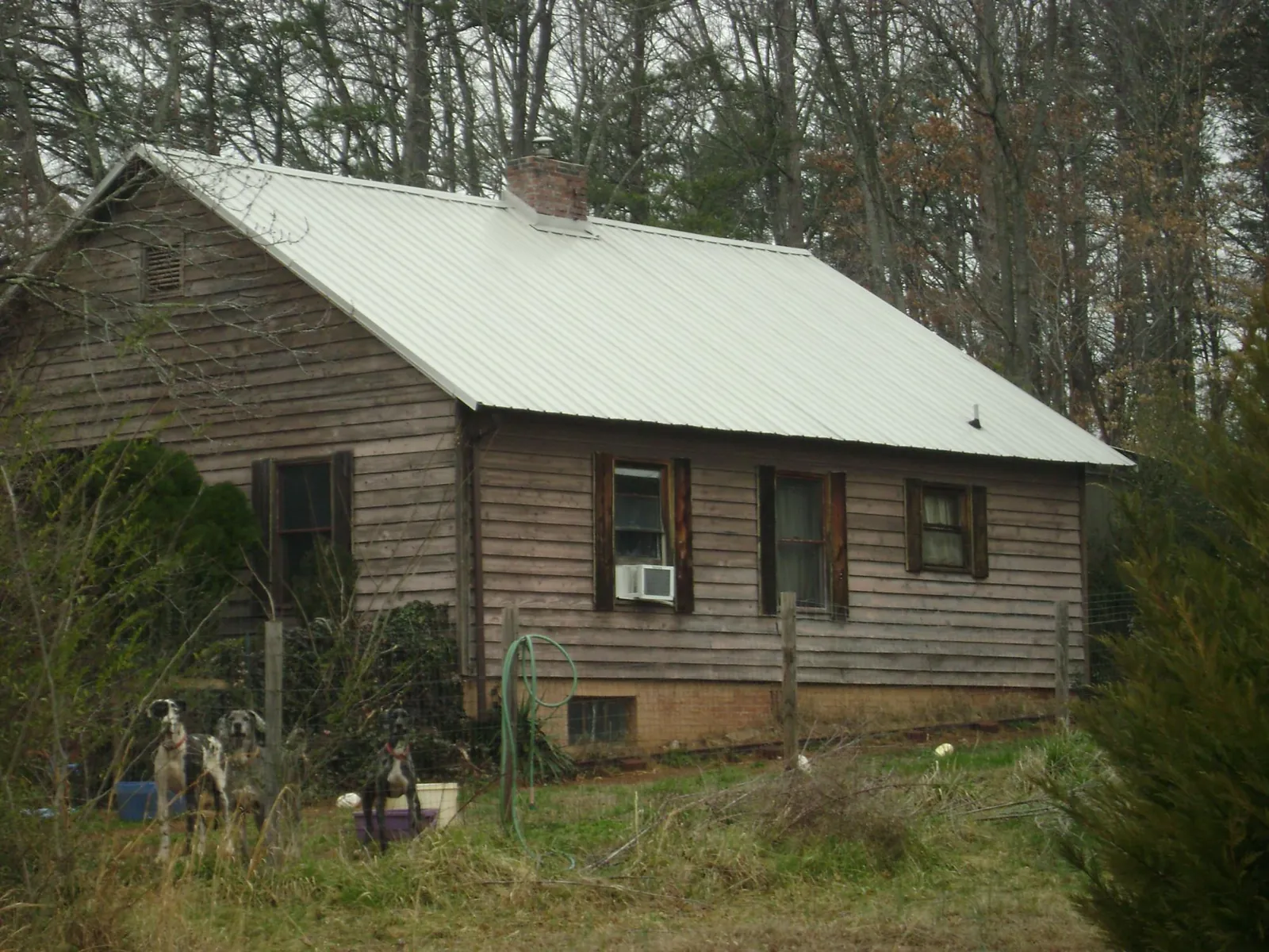 White metal roof on an old wood sided farmhouse, from a Metal Roof Installation job in Merced